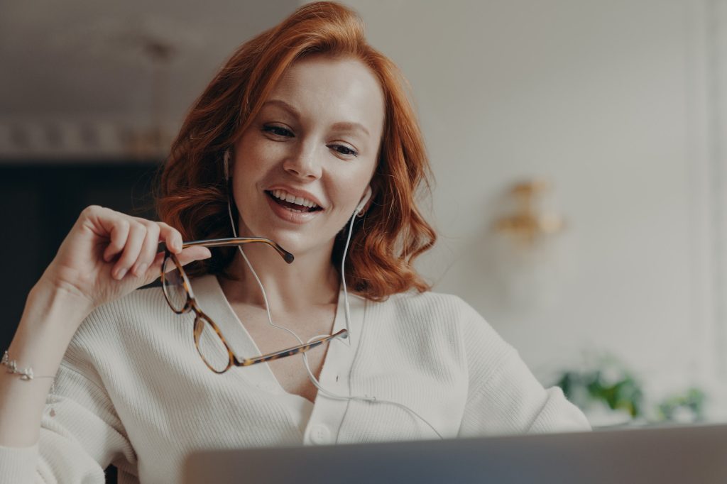 woman concentrated in laptop computer, watches video or movie on laptop